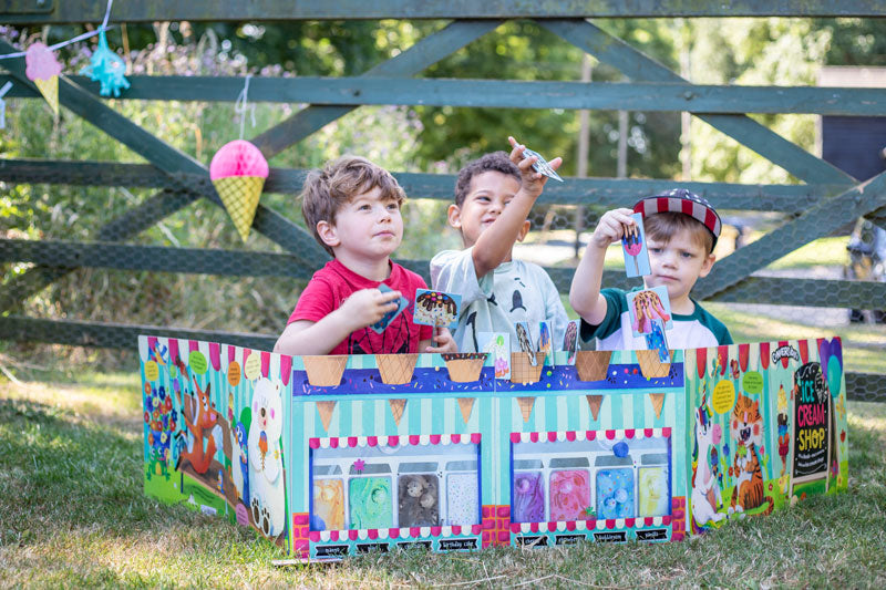 Convertible Ice Cream Shop by Miles Kelly is being played with by three young boys. They are stacking together ice creams, whilst sitting inside the shop.